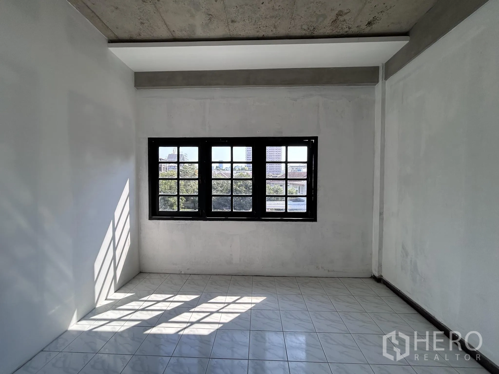 家庭办公室 for rent or sale in Watthana, Bangkok - 明亮瓷砖房，中央大窗俯瞰周边社区。