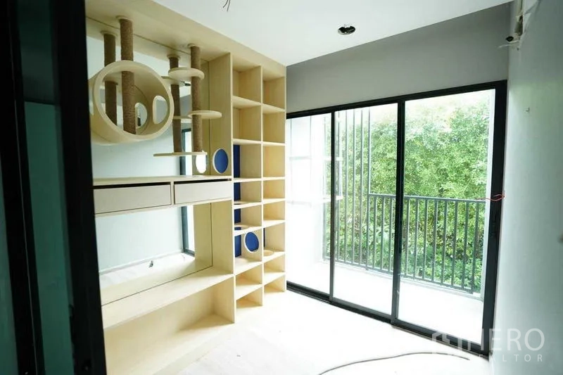 独立商业地产 出租在Bang Na, Bangkok - 内置层架与圆形装饰格的房间，旁有阳台推拉门。