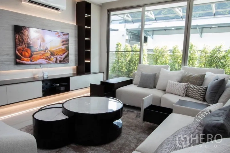 Detached House for sale in Saphan Sung, Bangkok - Bright lounge with sliding glass doors, garden outlook and a floating TV console.