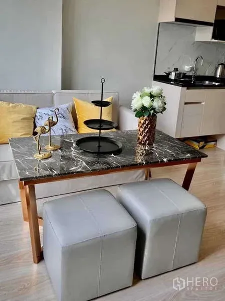 Condominium for rent - Marble-top dining table with stools beside a cozy sofa and kitchenette