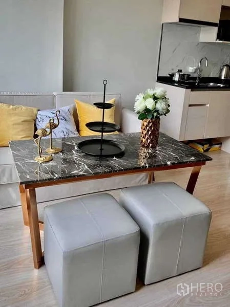 Condominium for rent - Marble-top dining table with stools beside a cozy sofa and kitchenette