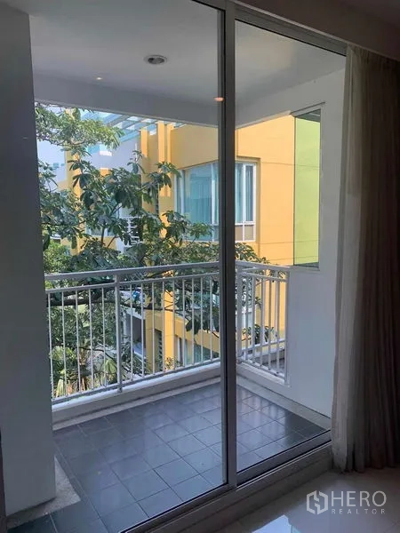 公寓 出租或出售在Khlong Toei, Bangkok - 推拉玻璃门阳台，眺望绿树与邻近建筑。