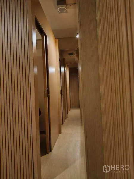 店屋 出租或出售在Watthana, Bangkok - 狭长走廊，木墙与多间房门。