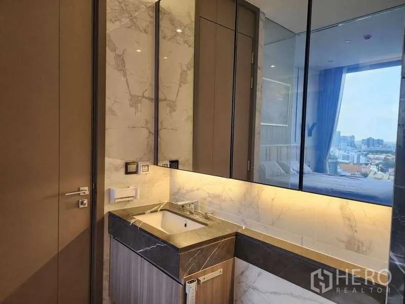 คอนโด ให้เช่าในWatthana, Bangkok - เคาน์เตอร์ล้างหน้าหินอ่อน กระจกไฟซ่อน พร้อมตู้เก็บของ เห็นห้องนอนผ่านผนังกระจก