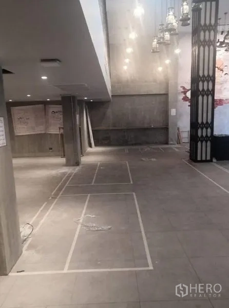 零售空间 出租在Watthana, Bangkok - 开放式零售空间，灰色地砖与嵌入式照明。