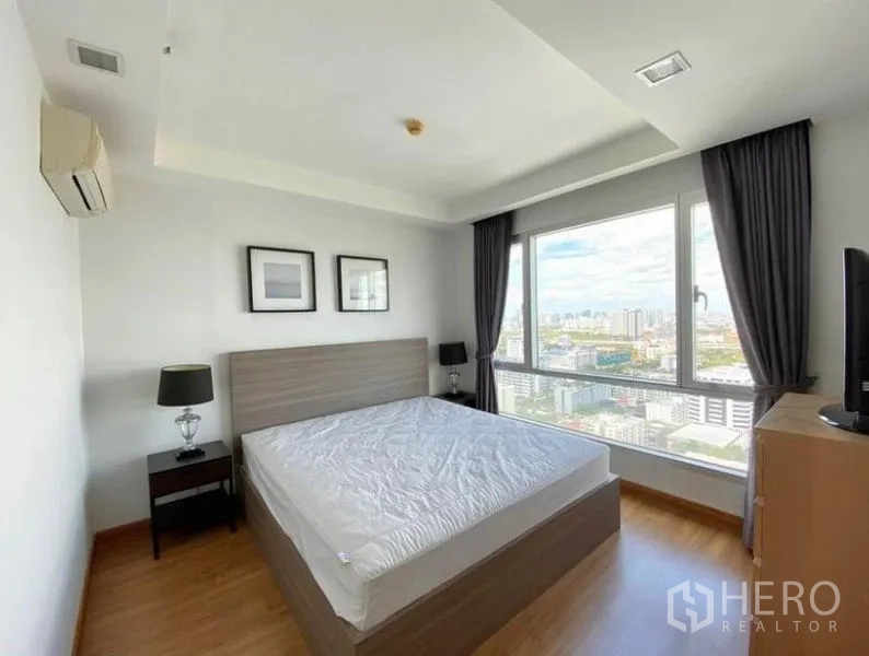 คอนโด ให้เช่าในHuai Khwang, Bangkok - ห้องนอนมาสเตอร์ หน้าต่างบานใหญ่ เตียงคู่ พร้อมวิวสกายไลน์เมือง