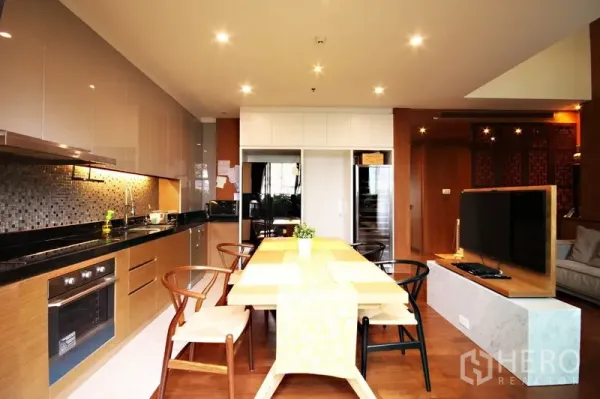 คอนโด ให้เช่าหรือขายในKhlong Toei, Bangkok - ครัวเปิดและพื้นที่ทานอาหารพร้อมผนังกระเบื้องโมเสก ตู้ไม้ และฉากกั้นทีวี