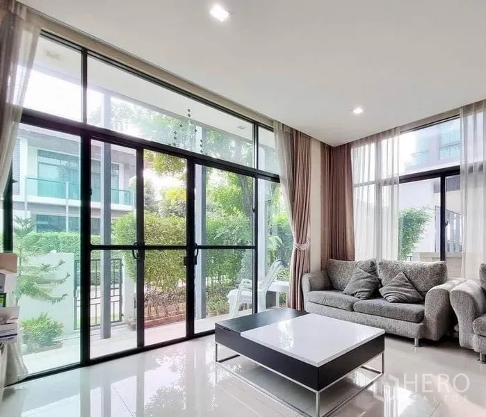 บ้าน ขายในPrawet, Bangkok - ห้องนั่งเล่นกระจกเต็มบาน โซฟาเข้ามุม และโต๊ะกลาง มองสู่สวน