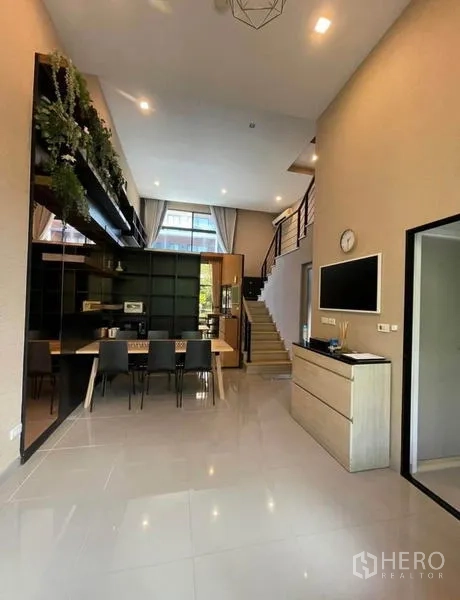 Townhouse for rent in Yan Nawa, Bangkok - Double-height living and dining area with open kitchen and staircase.