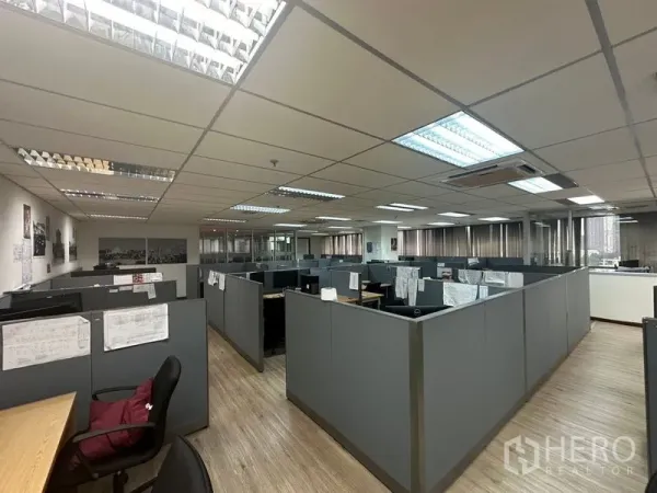 Office Space for rent - Large open-plan office with gray cubicles, fluorescent lighting and windows