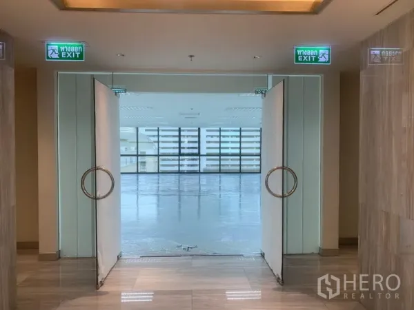办公空间 出租在Bang Rak, Bangkok - 双开玻璃门通向明亮的开放式办公室，前方为整面采光窗。