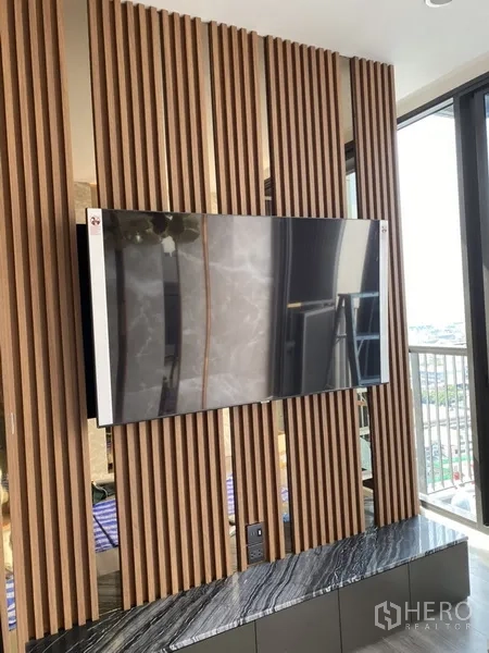 คอนโด ขายในPhra Khanong, Bangkok - ทีวีติดผนังซี่ไม้ เหนือเคาน์เตอร์หินอ่อน ใกล้ระเบียง