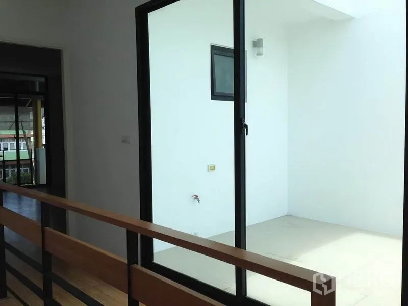 Townhouse for rent in Yan Nawa, Bangkok - Covered utility terrace with sliding glass door and wall tap.