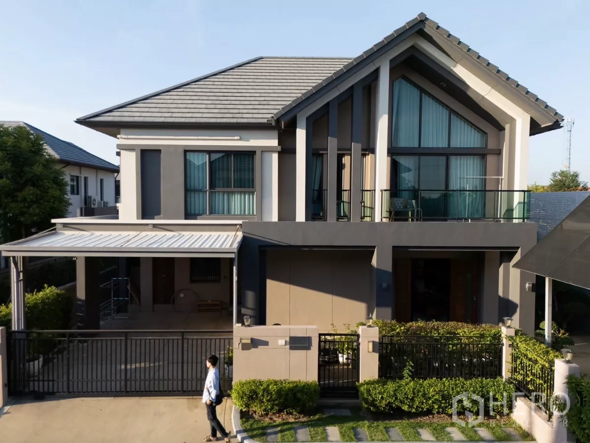 Detached House for rent or sale in Saphan Sung, Bangkok - Modern two-storey detached house with gated driveway, covered carport, balcony and trimmed hedges.