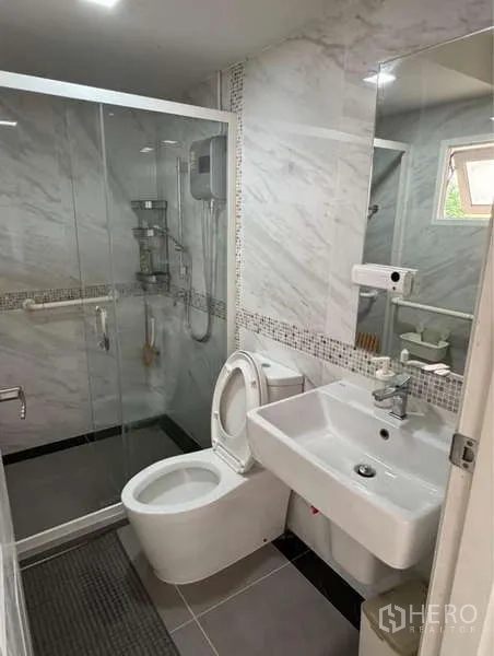 Detached House for rent in Bueng Kum, Bangkok - Modern bathroom with glass shower enclosure, toilet and basin.
