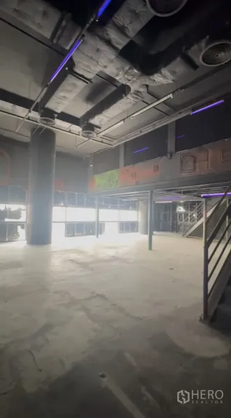 零售空间 出租在Khlong Toei, Bangkok - 高层高零售区，中央立柱、大窗与部分夹层。