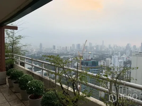 Condominium for rent or sale in Watthana, Bangkok - High-rise balcony with potted plants and panoramic views of the Bangkok skyline.