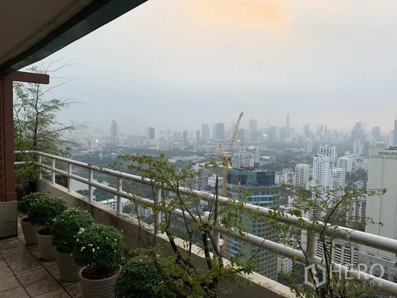 Condominium for rent or sale in Watthana, Bangkok - High-rise balcony with potted plants and panoramic views of the Bangkok skyline.