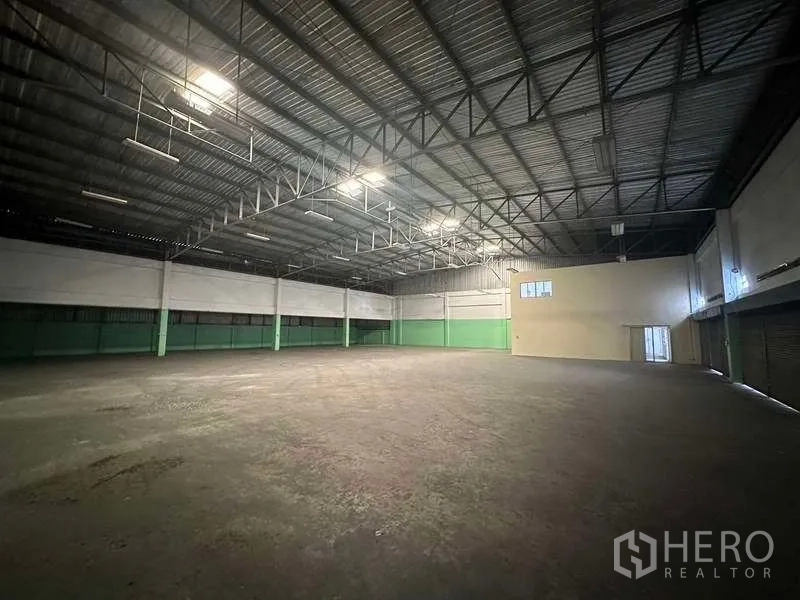 工厂 出租在Nonthaburi - 开阔生产区，桁架天花、下墙绿色，并沿侧墙设装卸门。