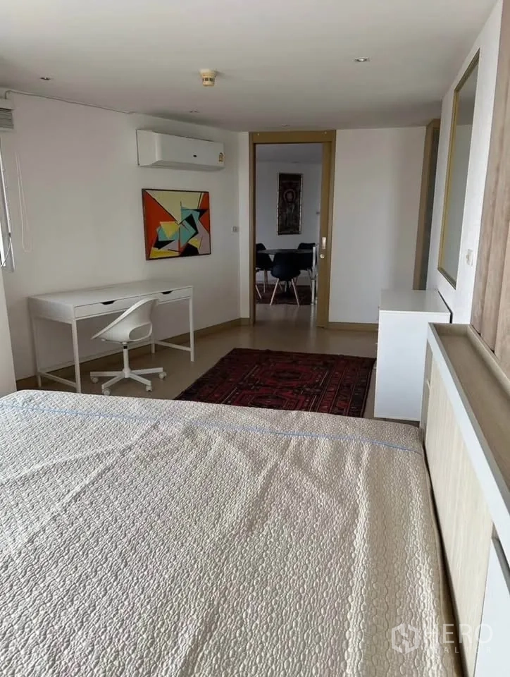 Condominium for rent or sale in Yan Nawa, Bangkok - Spacious bedroom with bed, work desk, air conditioning and rugs.