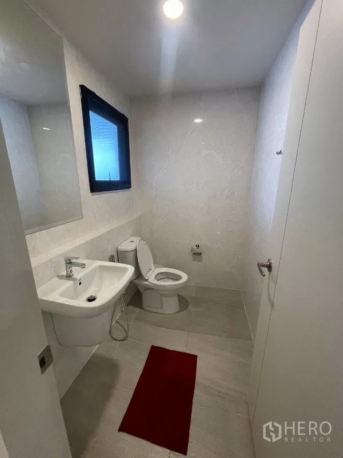 独立式住宅 出租在Bang Phli, Samut Prakan - 干净的客卫，挂墙式台盆与坐厕，浅色瓷砖。