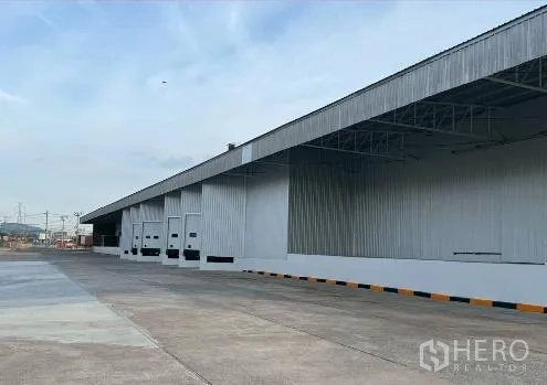 Factory for rent in Si Racha, Chon Buri - Row of dock doors with canopies and truck aprons along the building.