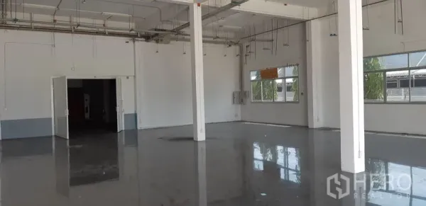 Factory for rent in Lat Krabang, Bangkok - Open production area with polished epoxy floor, white columns, and ceiling utilities.