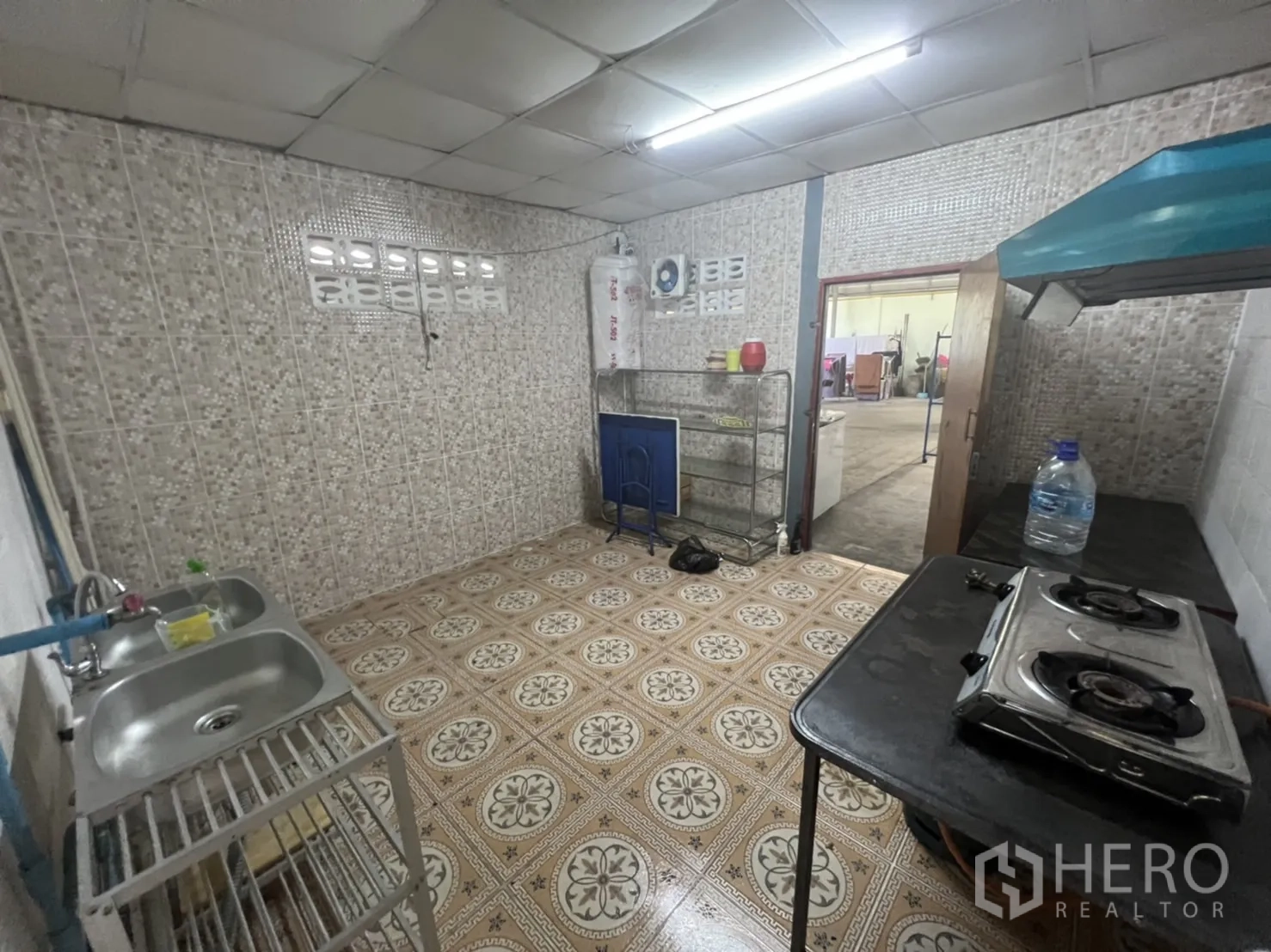 零售空间 出租在Watthana, Bangkok - 后方服务间，瓷砖墙面，水槽，燃气灶与排油烟机，适合简易备餐。