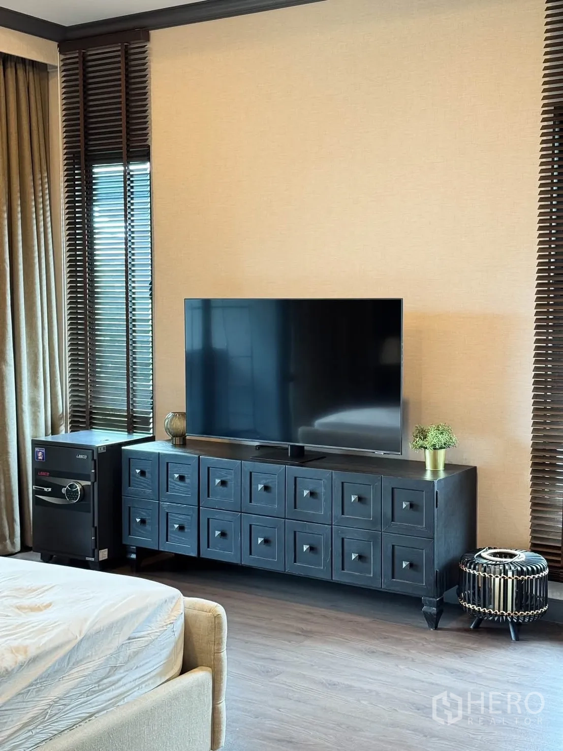บ้านเดี่ยว for rent in Bang Kapi, Bangkok - มุมทีวีในห้องนอนใหญ่ ตู้คอนโซลสีเข้มและมู่ลี่หน้าต่าง