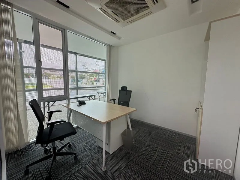 Office Space for rent - Corner executive office with large windows, roller blinds, and a single workstation.