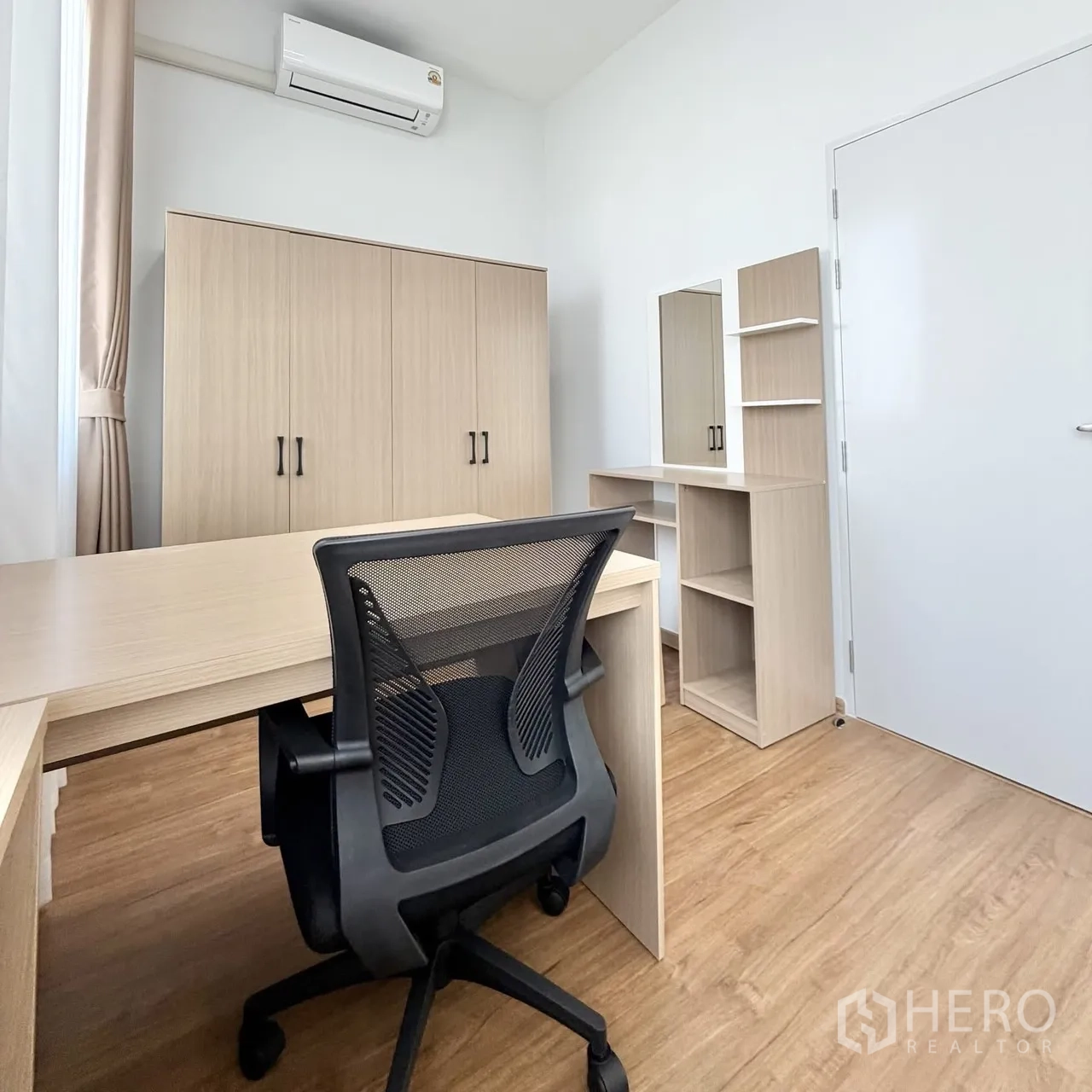 Townhouse for rent in Bang Phli, Samut Prakan - Home office or bedroom with desk, mesh chair, wardrobe, and air conditioning.