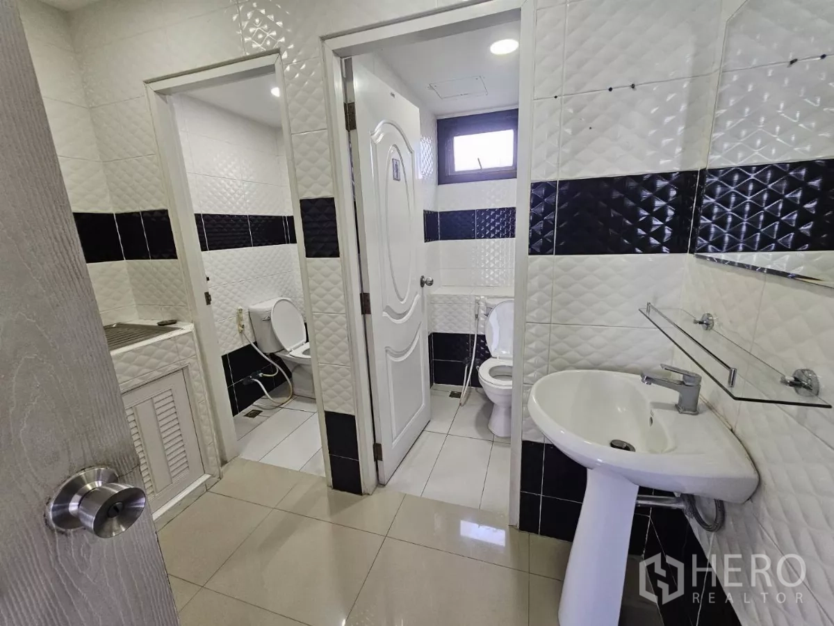Office Space for rent in Sathon, Bangkok - Restrooms inside the office with pedestal sink, two toilets and patterned wall tiles.