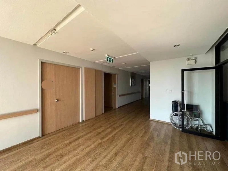 独立商业地产 出租在Bang Kapi, Bangkok - 明亮走廊，木质地板，多扇门与玻璃入口，放置轮椅，医疗级装修。