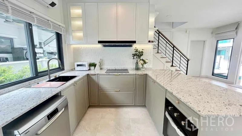 Detached House for rent in Bang Phli, Samut Prakan - Bright U-shaped kitchen with stone countertops, window and built-in appliances