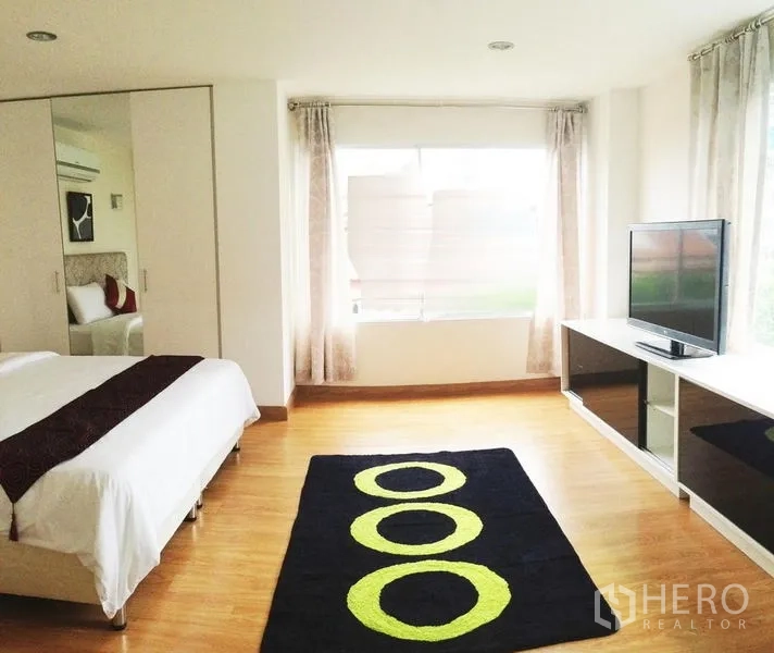 คอนโด ให้เช่าในKhlong Toei, Bangkok - ห้องนอนใหญ่ หน้าต่างบานกว้าง ตู้เสื้อผ้าบานกระจก ทีวี และพรมลายวงกลม