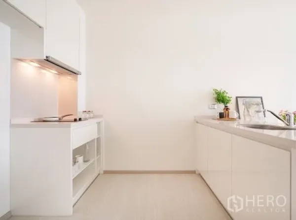 公寓 出售在Khlong Toei, Bangkok - 现代白色厨房，带橱柜下照明、水槽与开放式置物架。