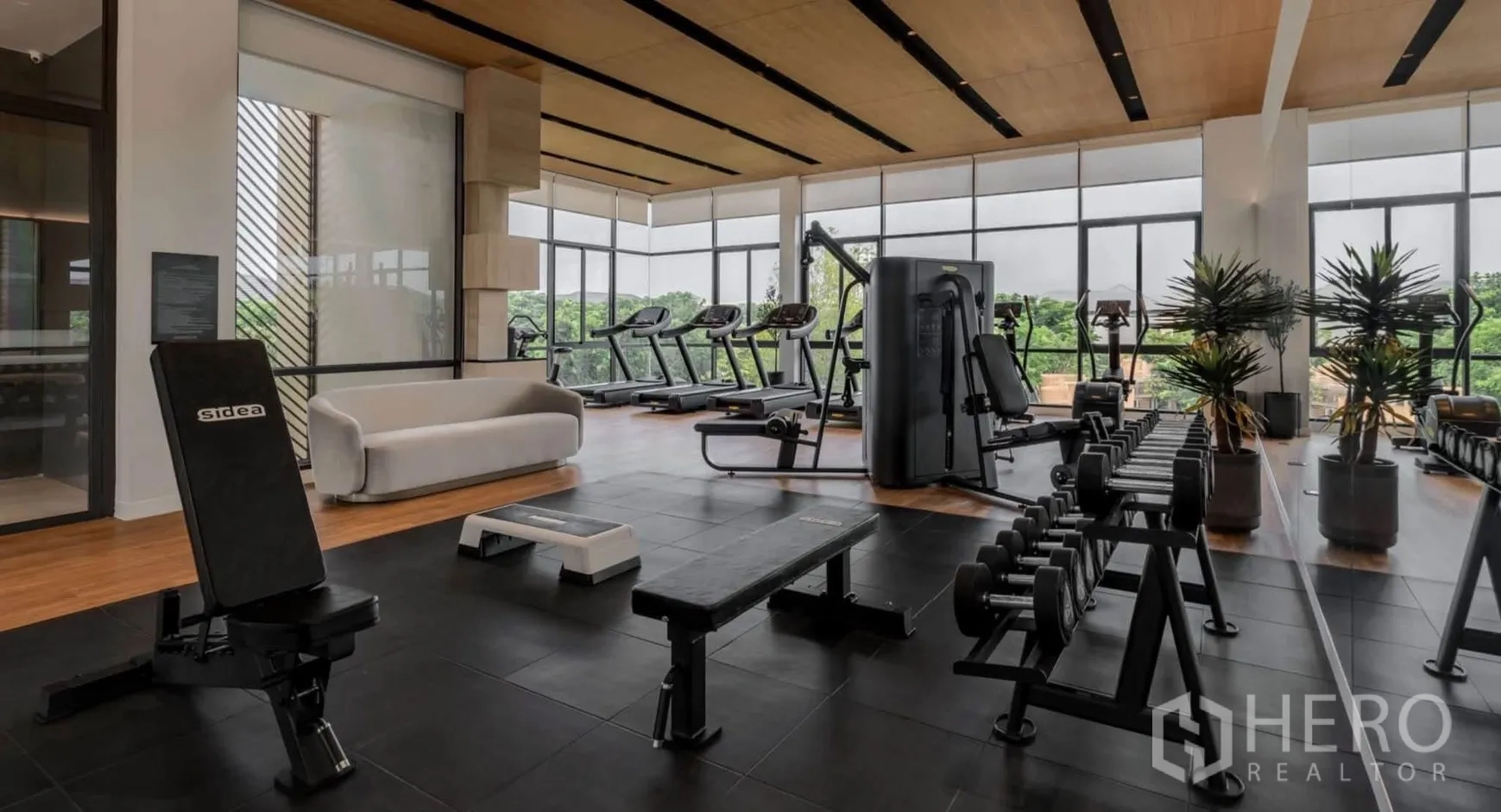 Detached House for rent in Bang Phli, Samut Prakan - Well-equipped gym with treadmills, weights, and large windows facing greenery.