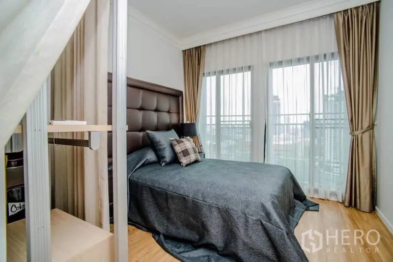 Condominium for rent or sale in Watthana, Bangkok - Second bedroom with large glass doors to the balcony and city view.