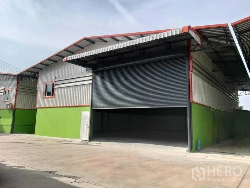 Warehouse for rent in Bang Khun Thian, Bangkok - Modern warehouse exterior with large roller shutter and covered loading bay.