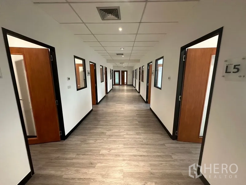 办公空间 出租在Khlong Toei, Bangkok - 办公楼层走廊，排列整齐的木门与吊顶灯