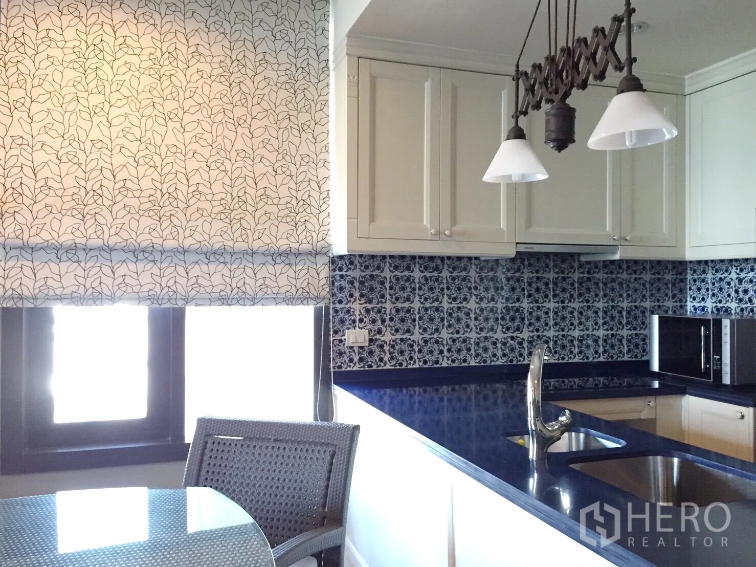 คอนโด ให้เช่าในKhlong Toei, Bangkok - ครัวบิวท์อินตู้สีขาว กระเบื้องลายสีน้ำเงิน และโคมไฟแขวน เห็นอ่างล้างจานคู่