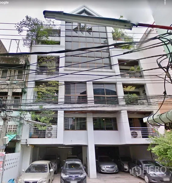 办公空间 出租在Ratchathewi, Bangkok - 城市中层办公楼，大片玻璃立面，绿植阳台与楼下遮棚停车位。