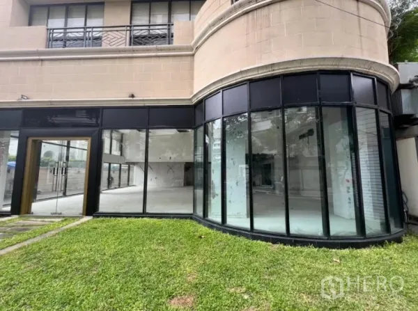 พื้นที่ขายปลีก ให้เช่าในWatthana, Bangkok - ด้านหน้าอาคารมุมกระจกโค้ง ชั้นล่าง กระจกเต็มบาน พร้อมสนามหญ้า