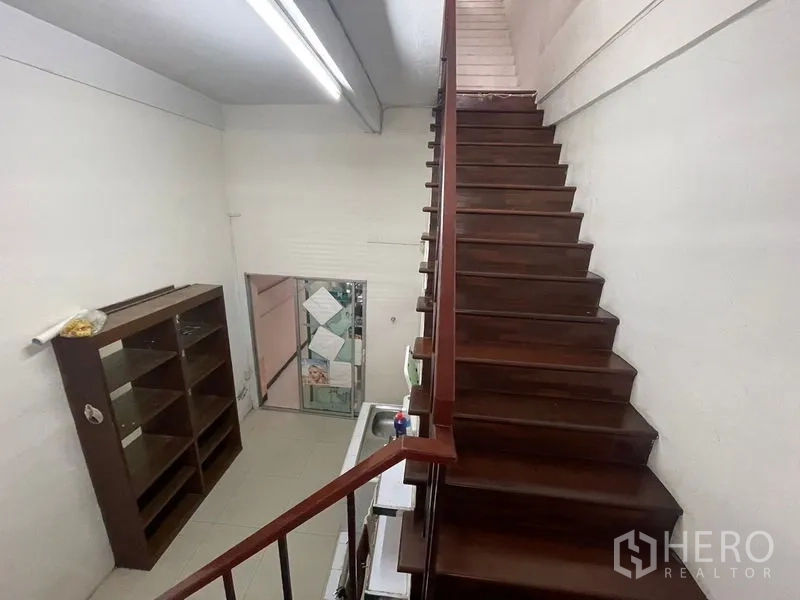 店屋 出租在Phra Khanong, Bangkok - 木楼梯上行，旁有水槽与开放式置物架。