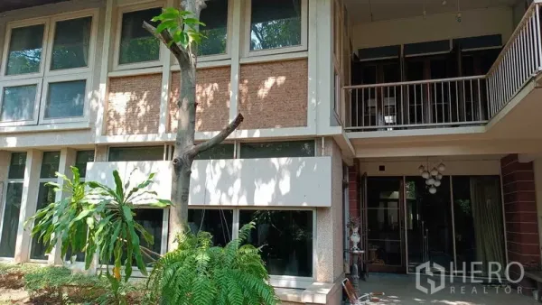 独立式住宅 出租在Phaya Thai, Bangkok - 帕亚泰两层独栋别墅外观，大面积窗户、阳台与树荫花园。