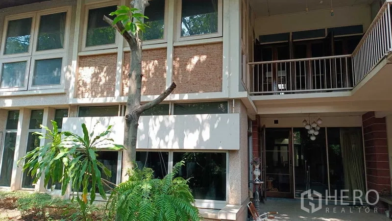 独立式住宅 出租在Phaya Thai, Bangkok - 帕亚泰两层独栋别墅外观，大面积窗户、阳台与树荫花园。