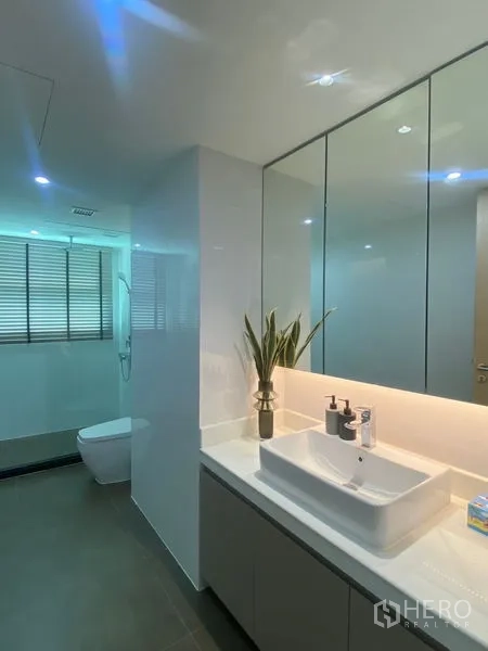 Condominium for rent in Watthana, Bangkok - Modern bathroom with vessel sink, mirrored cabinets, and separate shower area.