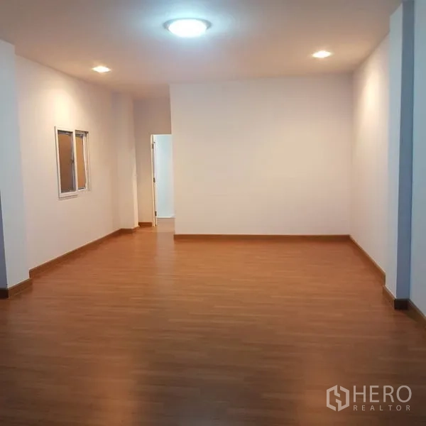 สำนักงานที่บ้าน ขายในLat Phrao, Bangkok - ห้องเปิดโล่งติดไฟดาวน์ไลท์ พื้นไม้ พร้อมประตูสู่ส่วนใช้งาน