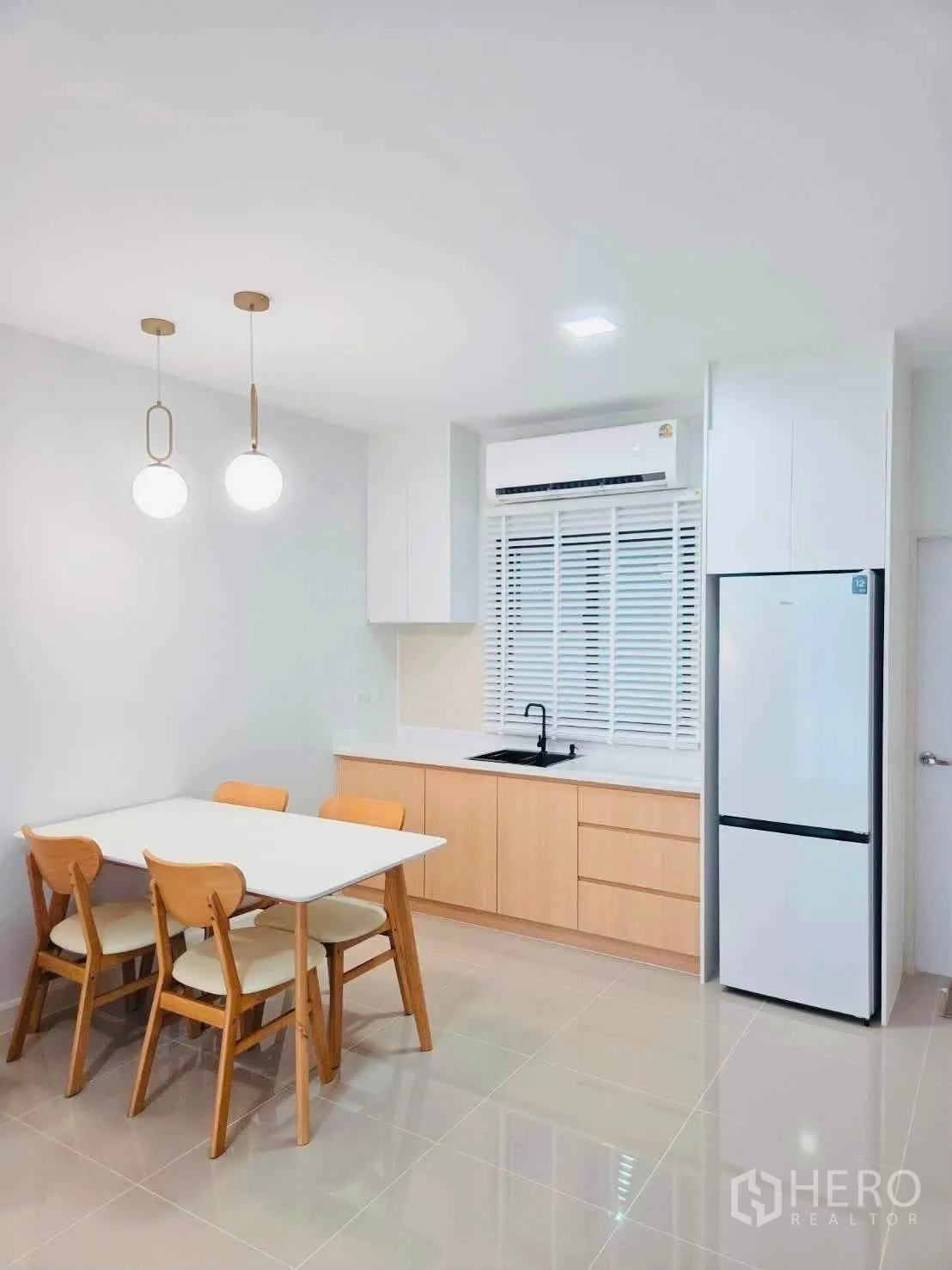 联排别墅 for rent in Bang Phli, Samut Prakan - 餐区连同备餐厨房，吊灯与冰箱。