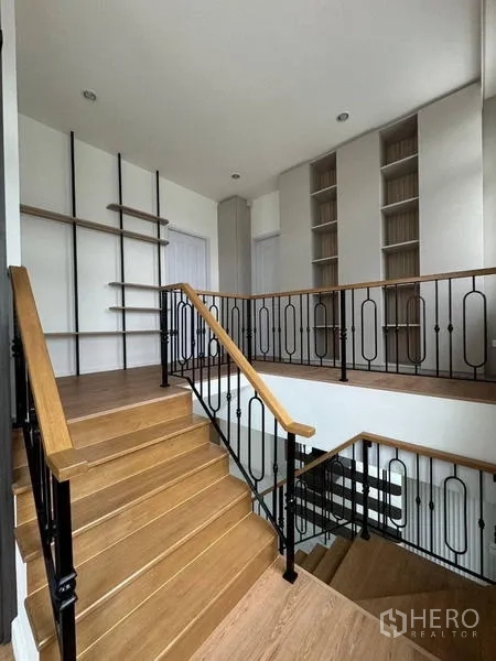 Detached House for rent - Staircase and landing with wood steps and black iron balustrade, built-in shelves